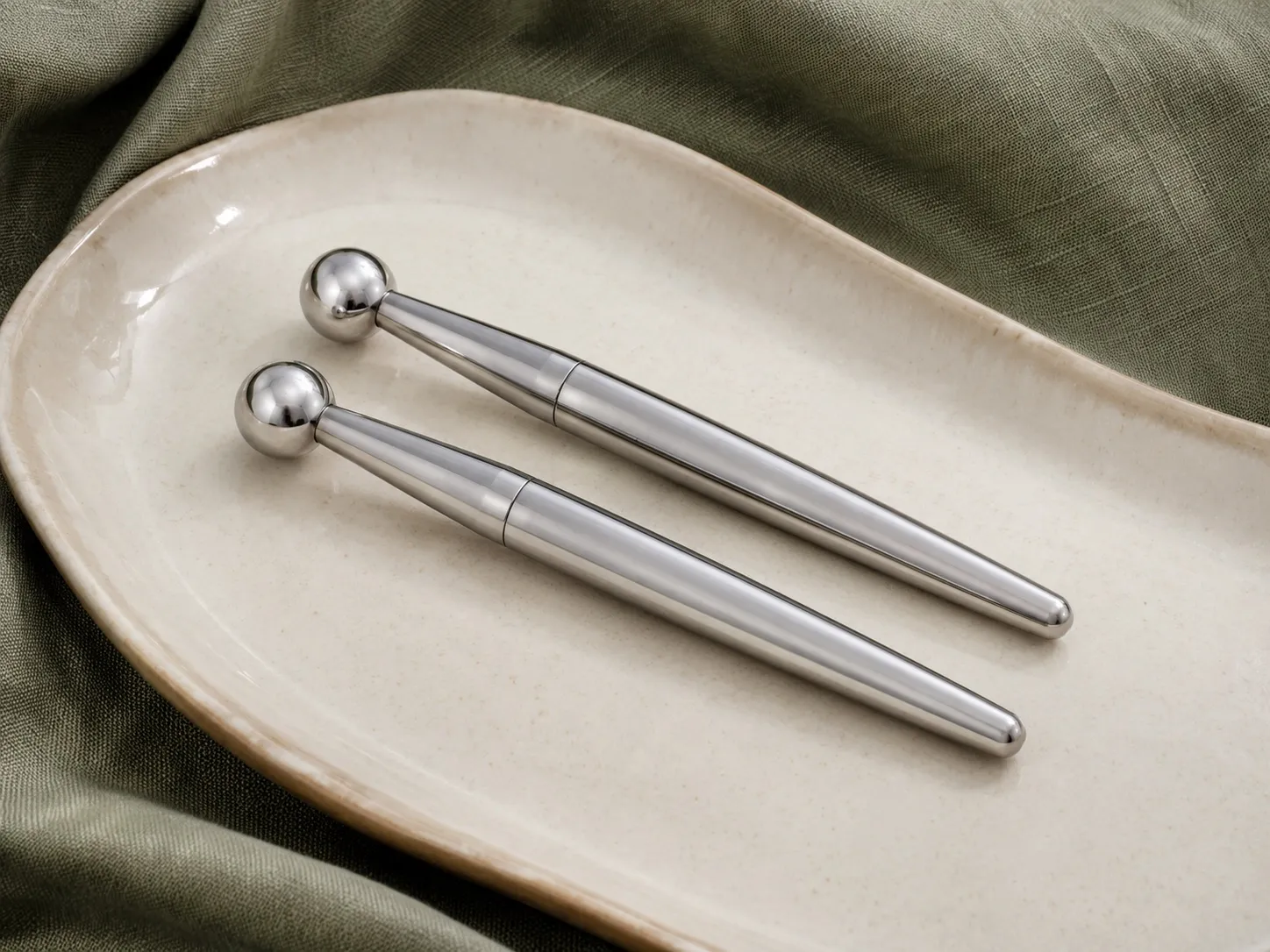 Twin metal microcurrent wands on a ceramic tray at Uneka Facials in Lodi